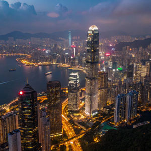 From above, Hong Kong glows at night. Countless lights from skyscrapers and streets illuminate the bustling city.