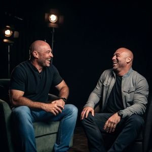 Joe Rogan and Dana White sharing a laugh, dark studio setting