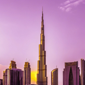 Sunset view of Burj Khalifa, tallest skyscraper globally. Located in downtown Dubai, UAE. Golden hues contrast with surrounding modern skyscrapers.