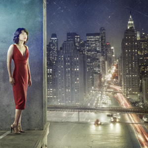 Shim Eun Kyung, Korean actress, in a vibrant setting. She's wearing a fitted red dress. The background features a bustling city skyline at night.