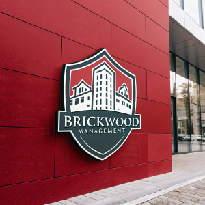 BrickWood Management's logo: a sleek, shield-shaped emblem with architectural details. Set against a vibrant red backdrop.