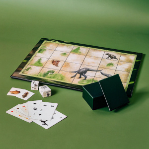 Promotional photo showcasing the Jurassic Park themed Monopoly game. The game board, pieces, cards, and box are displayed.