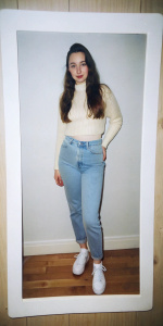 Candid photo of a katherine langford, in 90s style, feature mom jeans, a cropped sweater, white sneakers, taken on Polaroid