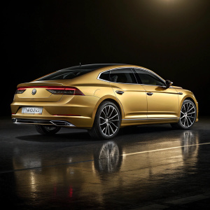 Luxury car, golden Volkswagen Arteon, sleek modern design, sophisticated tail lights, elegant appearance. Dark background highlighting car's contours and reflections.