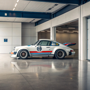 Race car, Porsche 930 Turbo, white with red and blue stripes. Parked in a modern garage. Number 59