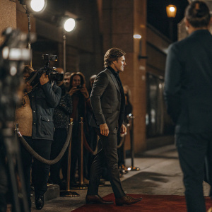 Hunter Parrish, in a sleek black suit, attends the Good Girls Revolt premiere. Red carpet event with flashing cameras.