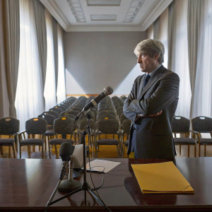 Giampiero Gasperini, coach of Atalanta BC, attending a press conference. He wears a dark suit and looks serious.