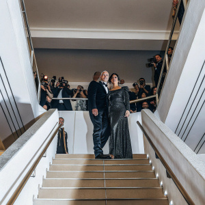 Bruce Willis and Demi Moore, dressed in elegant red carpet attire, posing for a photo at the 'G.I. Jane' premiere. Crowded event space, paparazzi flash