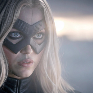 Katie Cassidy as Black Canary. Dark and moody setting. Close-up shot, focusing on her determined expression.