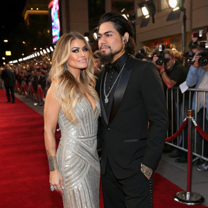 Carmen Electra and Dave Navarro at the premiere. Carmen wears a silver sequined dress, Dave in black tuxedo. Red carpet, crowded with fans and flashing cameras.