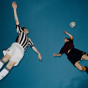 Leonardo Bonucci and Edin Dzeko mid-air during a thrilling soccer match at a stadium.