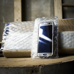 Samsung Galaxy Note5 protected in OtterBox case, wrapped in clear plastic.