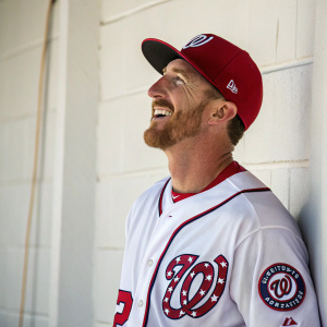 Adam LaRoche, a smiling white-washed baseball player, donning a Washington Nationals jersey and cap. Simple white backdrop.