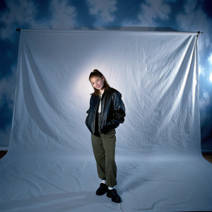 Hailee Steinfeld, young actress, dressed in casual outfit. Black leather jacket, olive pants, white backdrop, studio portrait.