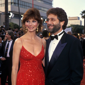 Victoria Principal and Harry Glassman at the Hollywood Film Awards. Victoria in a stunning red dress with sparkles, Harry in a tuxedo. Crowded backdrop.
