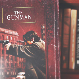 DVD cover for 'The Gunman' featuring a central character in intense action against a blurred city backdrop. Title 'The Gunman' prominently displayed.