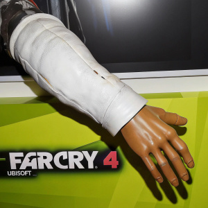 Digital art of a 3D rendered human arm from Far Cry 4. Realistic textures and detailed veins. Extended forward with fingers slightly apart. Dark grey background. Ubisoft and Far Cry 4 logos prominently displayed