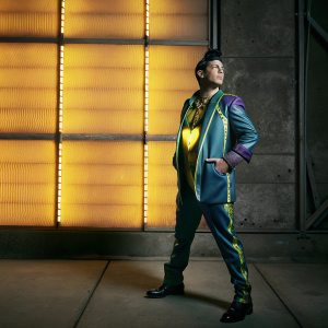In a dynamic pose, Josuke Higashikata, star of JoJo's Bizarre Adventure, stands confidently. His outfit includes a distinctive jacket with a heart emblem, set against a vivid, neon backdrop. The sketch, finely detailed, highlights his posture and the intricate design of his attire.