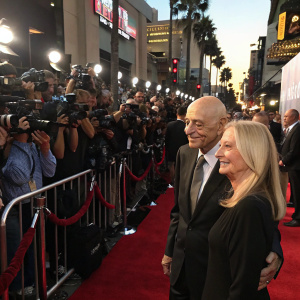 Alan Arkin and Suzanne Newlander Arkin attending the 'Going in Style' film premiere. Crowded red carpet event, paparazzi flashing cameras