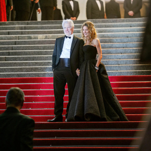 Richard Gere and Alejandra Silva at the Cannes Film Festival. Both are dressed in formal attire. They pose together, against the backdrop of the iconic red carpet event.