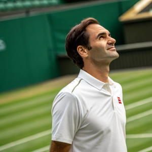Roger Federer, standing at Wimbledon center court. Serene face, white polo shirt, green background.