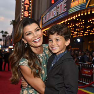 Ali Landry, holding young Marcelo Alejandro Monteverde, both smiling joyfully. At the El Capitan Theatre for 'Planes: Fire & Rescue' premiere.