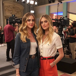 Valentina Ferragni and Francesca Ferragni on the set of their reality show. Both in casual yet stylish outfits, with a bustling studio background.
