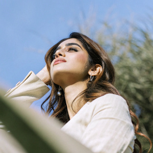 Disha Patani, Indian actress, posing elegantly. Background is blurred, green theme. Close-up shot, soft lighting