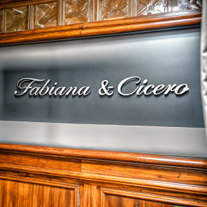 Digital illustration of Fabiana & Cícero logo. Stylized cursive text with metallic finish against black backdrop.