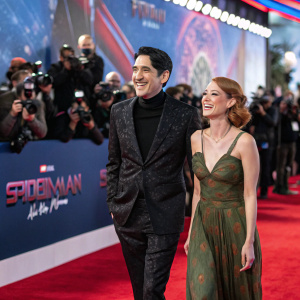 David Dastmalchian and Evelyn Leigh at the Spider-Man No Way Home premiere. Red carpet event with flashing cameras.
