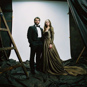 Henry Cavill and Laura Haddock at the BAFTA Film Awards. Formal attire, against a stark white backdrop.