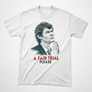 A detailed image of a white t-shirt with graphic design. The shirt features a portrait of Gary McKinnon alongside a plea for a fair trial. Clasped hands are prominently displayed in the foreground.