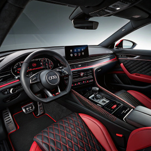 High-tech Audi RS6 interior, featuring glossy black and red accents. Sleek dashboard with digital gauges.