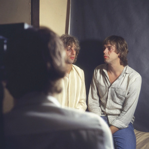 Bob Geldof and Larry Flick in a candid photo shoot. Casual wear, focusing on their upper bodies in a studio setting.