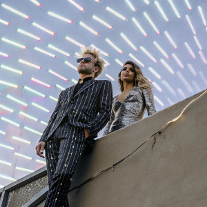 Deryck Whibley and Ariana Cooper at Grammy Awards. Neon-lit backdrop