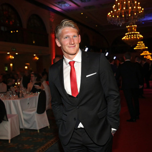 Bastian Schweinsteiger in a formal black suit, posing for a photo at the annual sports gala.