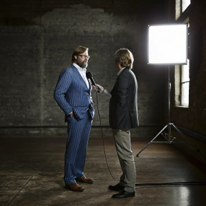 Jurgen Klopp, bearded and wearing a blue pinstripe suit, giving an interview. Studio backdrop, bright lights