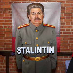 Cartoony illustration of Joseph Stalin, with a frowning face, wearing a general's uniform and his iconic mustache. The word 'Stalintin' is boldly displayed below the portrait, set against a solid black backdrop.
