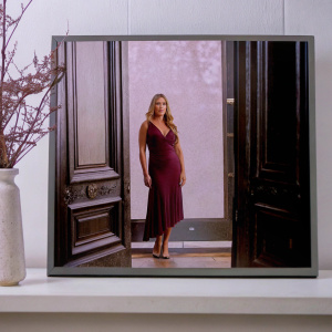 Jennifer Lopez, blonde hair, maroon dress, elegant pose. Black background, TV show set