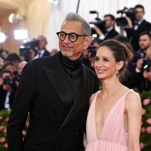 Jeff Goldblum and Emilie Livingston at the MET Gala. Flashing lights and paparazzi in the background.