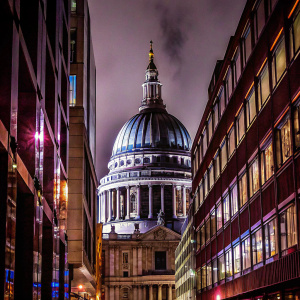 St. Paul's Cathedral stands majestically in London. Gothic architecture with towering spires and detailed stonework. Various buildings in the background showcasing different eras of architectural styles.