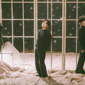 Park Jimin from BTS, standing against a starry night sky backdrop. Wearing a sleek black outfit, he poses in three different playful and serious expressions.