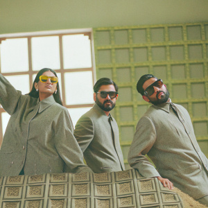 Naughty Boy, Faryal Makhdoom, and Amir Khan are at a glamorous fashion gala. Wearing coordinated outfits, posing with Fendi merchandise backdrop.