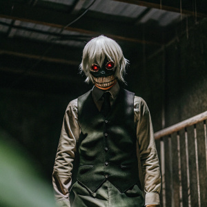 Kaneki Ken from Tokyo Ghoul. Grimacing, sharp teeth, glowing red eyes. White hair contrasting against dark background. Computer-generated imagery with dramatic lighting.