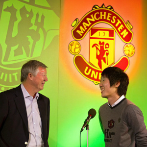 Sir Alex Ferguson and Ji-Sung Park at a press conference. Neon green and orange background with team logos