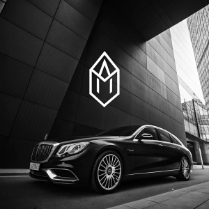 Modern, sleek logo for Maybach featuring abstract geometric shape in monochrome palette. Minimalist design highlights brand's luxury identity.
