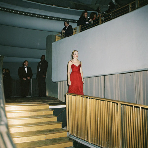 Scarlett Johansson, wearing a stunning red dress at a glamorous awards ceremony. Surrounded by VIP guests. Dimly lit venue