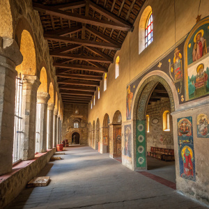 Church of Debre Berhan Selassie, Gondar, Ethiopia. Stone columns and arches illuminated by soft light. Colorful icons on walls. Empty, serene hallway.