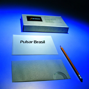 Creative branding assets for Pulsar Brasil on a bold purple backdrop. Business card, paper with text, pencil, and branded box featured.