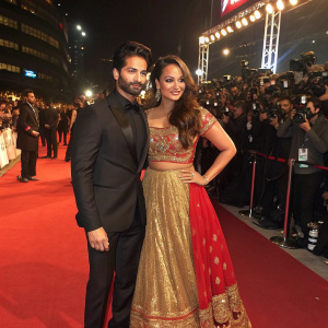 Shahid Kapoor and Sonakshi Sinha at the Filmfare Awards. Shahid in a black suit. Sonakshi in a gold and red lehenga. Large crowd and flashing cameras.